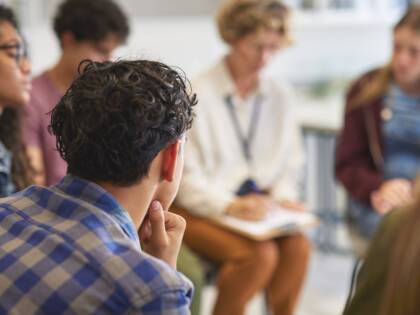 Människor sitter i en ring och diskuterar.