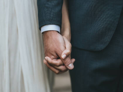 A bride and groom holding hands.