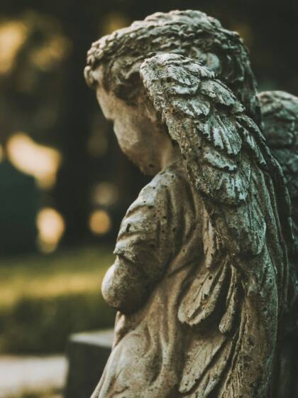 Statue of a small child with angel wings, on a graveyard.