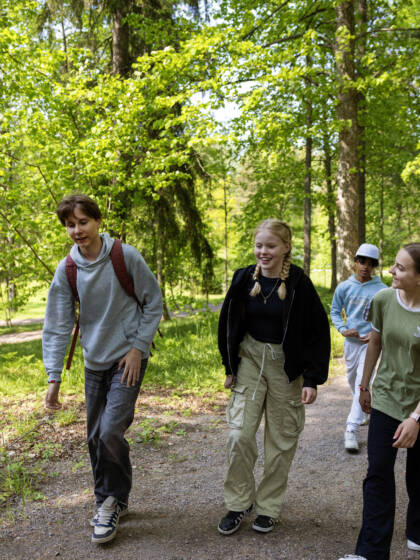 Ungdomar promenerar i skogen.