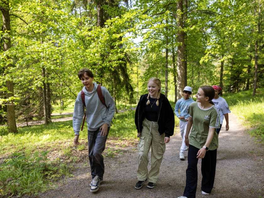 Ungdomar promenerar i skogen.