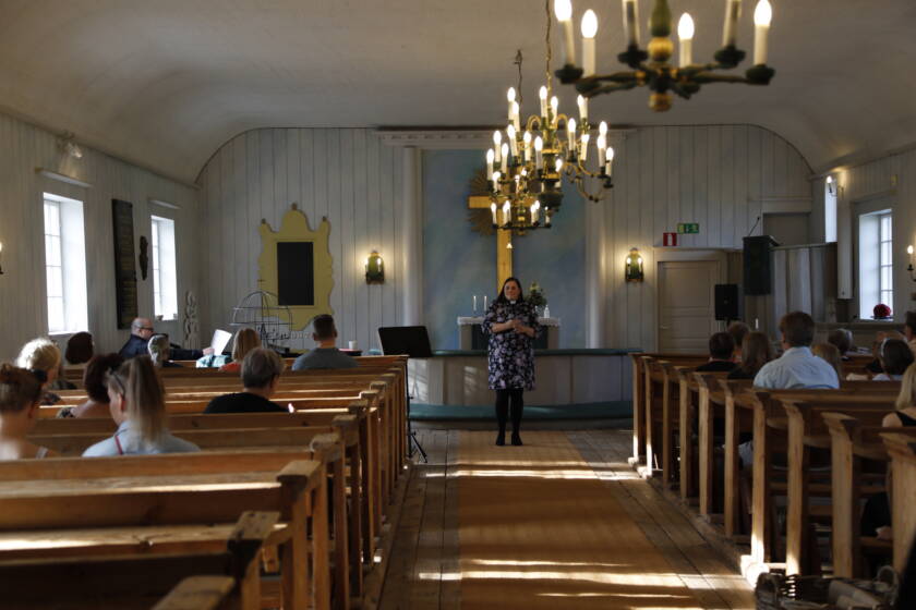 Kellokosken kirkko sisältä, pappi ja seurakuntalaisia