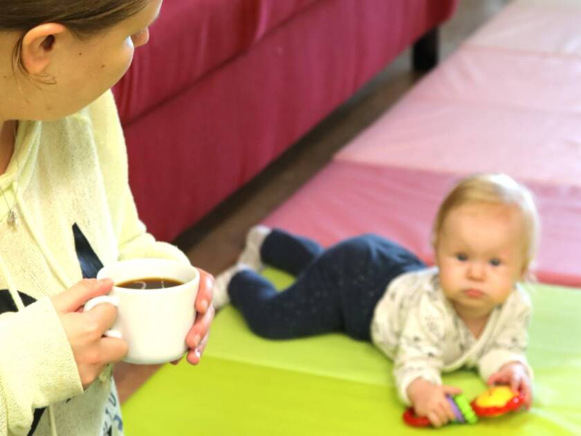 vauva ja äiti kahvikupin kanssa