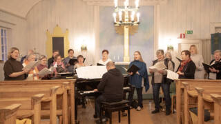 kuorolaisia laulamassa kirkon etuosassa
